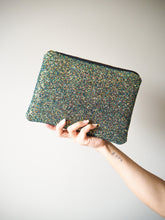 This sparkly black clutch bag is handmade and comes with a black YKK zip with gold hardware, keeping your belongings safe inside the main compartment.