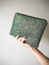 This handmade glitter clutch bag has a black base with s shimmer of copper, gold, brown, and green. This handmade clutch bag looks great with a little black dress for a special occasion.