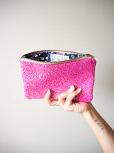 The inside of this hot pink glitter makeup bag has a navy floral print lining to match with a 'Suki Sabur' branded label.