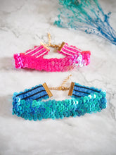 These sparkly sequin chokers come in two colours that you can choose from, both the mermaid blue and hot pink having an iridescent shimmer and an adjustable chain fastening.