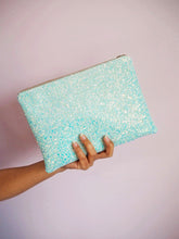 This pastel blue glitter clutch bag is handmade out of a sturdy canvas fabric with 100% cotton for the lining inside that has a floral print.