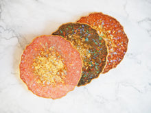 These Handmade Resin Coasters Burnt Orange are made by Suki Sabur and contain a sparkly gold and iridescent rainbow centre and a gold painted edge.