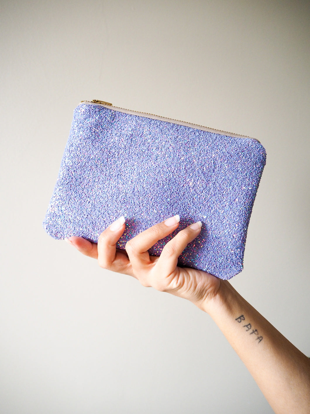 This handmade lilac glitter makeup bag comes with a YKK zip with gold hardware and a cotton lining inside.