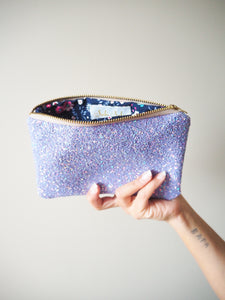 This sparkly lilac zip pouch can be used as a small clutch bag, a makeup bag, or a travel case to store your passport and travel documents or cash.