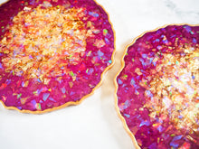 These Plum Geode Heatproof Resin Coasters Set are handmade by Suki Sabur and have an iridescent and gold shimmer on the surface with a metallic gold edge.